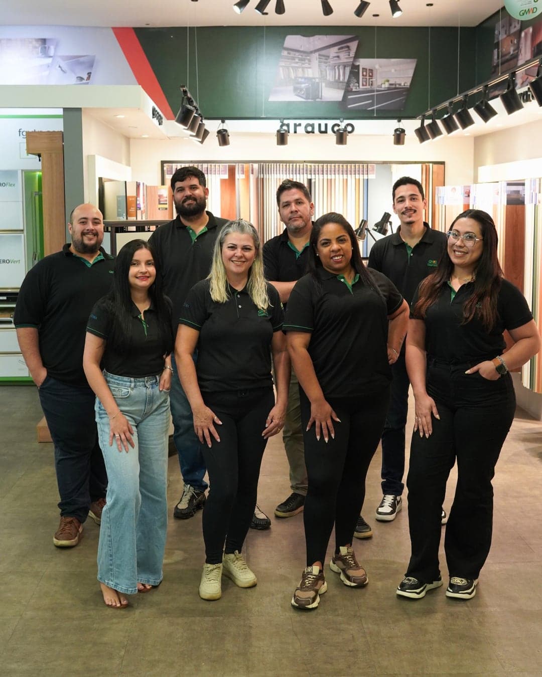 Time comercial da GMAD Campinas, oito pessoas de camisa preta da loja, reunidas no showroom.